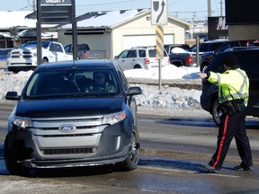 A Saskatoon Police Service officer pulls over a car Wednesday on Idylwyld Drive North on Wednesday, March 7, 2018 where the SPS was holding a distracted driving enforcement event in conjunction with SGI. Police were looking for drivers holding, using manipulating or viewing handheld cell phones or otherwise driving without due care and attention. Drivers caught in the act were being handed a $280 ticket. (Jeff Losie/Saskatoon StarPhoenix)