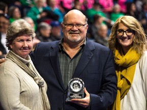 The Regina Leader-Post's Murray McCormick is flanked by his wife Marian, left, and daughter Mallory after receiving the Paul McLean Award at the Brier on Saturday.