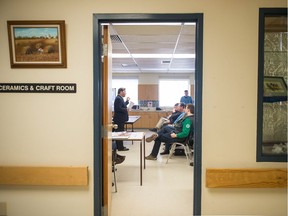 Attendees listen as MP Don Davies, left speaks at a town hall event promoting universal pharmacare at the Regina Senior Citizens Centre in Regina.