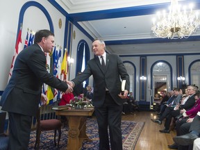 Gordon Wyant, left, and Don Morgan, centre, shake hands during a swearing in ceremony held at Government House. Wyant was appointed deputy premier and education minister; Morgan remained justice minister and attorney general among other portfolios.