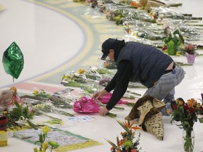 Al Lemoignan places flowers at centre-ice in Humboldt's Elgar Petersen Arena on April 11.