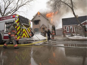 Saskatoon firefighters work to put out a fire at a home on Avenue C North on April 16, 2018.