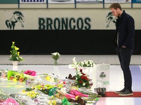 NHL player Connor McDavid visits the on-ice memorial at the Elgar Peterson Arena to pay his respects to the Humboldt Broncos hockey players who lost their lives in a bus crash in Humboldt, Sask., on April 17, 2018.