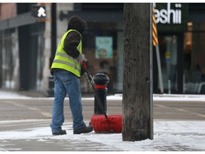 A man shovels the walkway on Broadway Avenue after a snowfall in Saskatoon, Sask., on April 17, 2018.