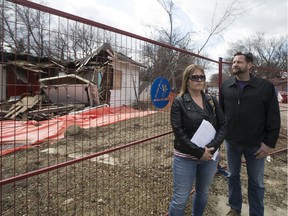 Shannon Vinnish (L) and Daniel Gerle stand outside a home on the corner of Avenue B and 34th Street that has been left partly demolished for more than six months with asbestos warnings on the fence in Saskatoon, SK on Wednesday, April 25, 2018.