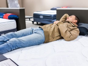 Young man tries mattress in store.