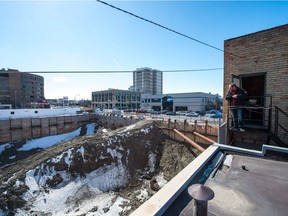 Chris Thorsteinson, manager of Bregg Cleaners stands, outside the second story of the business, looking out over the Capital Pointe building site on the intersection of Albert Street and Victoria Avenue.