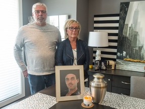 Wayne Wakelam and Jenny Churchill stand in Churchill's home in front of a photo of their son, Jordan Wakelam, who struggled with an opioid addiction and died on Jan. 27, 2018, of an overdose.
