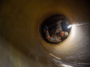 Adriano Coronado, a final inspector, closely looks over the inside of a section of pipe at the Evraz steel plant in Regina.