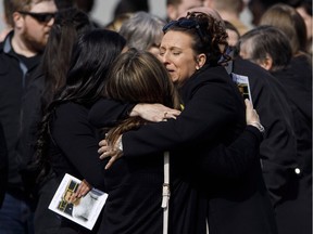 Mourners hug after the funeral for Humboldt Broncos player Conner Lukan in Slave Lake, Alta. on Wednesday, April 18, 2018.