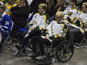 Survivors Graysen Cameron, right, and Derek Patter watch a tribute during the funeral of Humboldt Broncos player Evan Thomas in Saskatoon, Sask., Monday, April, 16, 2018.