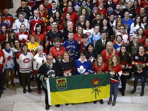 The flag of Saskatchewan is held in the Hall of Honour on Parliament Hill as parliamentary and political staff pose for a group photo while wearing jerseys in tribute to the victims of the Humboldt Broncos bus crash, in Ottawa on Thursday, April 12, 2018.