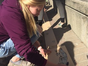 Grade 8 EcoQuest students use handmade clay paint to stencil a red fox and it's tracks around River Landing in anticipation for the upcoming Nature City Festival in Saskatoon on April 27, 2018. (Erin Petrow/ Saskatoon StarPhoenix)