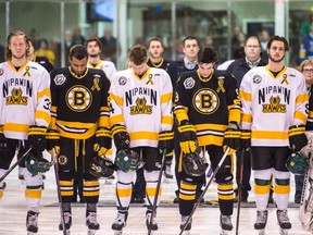 Players from the Nipawin Hawks and the Estevan Bruins stand on the ice for the national anthem at the Nipawin Centennial Arena prior to a game as the SJHL season resumes following the collision involving the Humboldt Broncos hockey team.