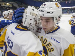Saskatoon Blades goalie Nolan Maier, left, and forward Chase Wouters celebrate their win over the Red Deer Rebels in WHL action in Saskatoon, SK on Friday, January 5, 2017.