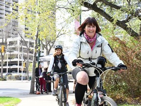 Wendy Cleveland (left) and Della Spearing (right) ride their bikes past the station set up near City Hall for YXE Bike to Work Day on May 16th, 2018. The City of Saskatoon and businesses around the city gave away food, coffee, and more to cyclists who came by during the morning.