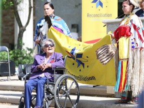World War II veteran Virginia Pechawis sits with the Reconciliation Flag at the flag-raising ceremony at City Hall in Saskatoon on May 29, 2018.