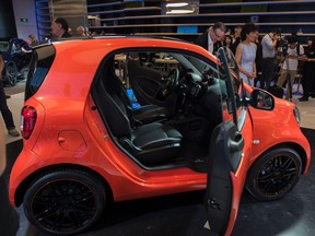Journalists take pictures of a tailor-made Smart "Fortwo" car by Brabus, at the Mercedes store as part of the "Auto China 2016" Beijing International Automotive Exhibition in Beijing on April 24, 2016.