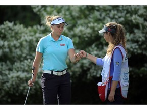 WILLIAMSBURG, VA - MAY 20: Brooke M. Henderson of Canada fist pumps her caddie after finishing her round on the 18th hole during the third and final round of the Kingsmill Championship presented by Geico on the River Course at Kingsmill Resort on May 20, 2018 in Williamsburg, Virginia. The tournament was shortened to three rounds due to inclement weather during round two.