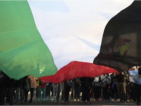 Demonstrators hold a Palestinian flag in front of Israel's embassy in Buenos Aires on May 15, 2018 during a protest against the killing of 60 Palestinians by Israeli fire in mass protests along the Gaza border, as the United States opened an embassy in Jerusalem.
