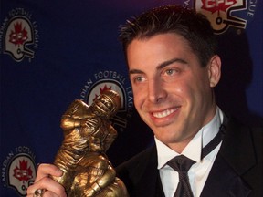 Hamilton Tiger-Cats slotback Mike Morreale holds the trophy after winning the CFL's Tom Pate Memorial Award for community service at the league's awards ceremony in Calgary on November 24, 2000.