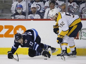 Winnipeg Jets' Brandon Tanev (13) and Nashville Predators' Matt Irwin (52) battle for the loose puck during second period NHL playoff action in Winnipeg on Monday, May 7, 2018.