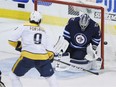 Nashville Predators' Filip Forsberg (9) shot is stopped by Winnipeg Jets goaltender Connor Hellebuyck (37) during third period NHL playoff action in Winnipeg on Monday, May 7, 2018.