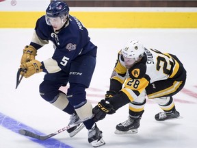Hamilton Bulldogs' Marian Studenic fights for control of the puck with Regina Pats' Josh Mahura during second period Memorial Cup action in Regina on Friday May, 18, 2018.