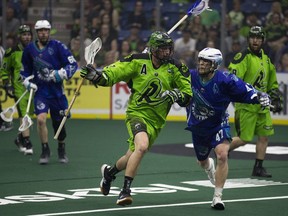 Saskatchewan Rush defense Brett Mydske runs with the ball as Rochester Knighthawks forward Kyle Jackson comes from behind during the game at SaskTel centre in Saskatoon, SK on Saturday, May 26, 2018.