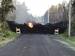 This photo provided by Hawaii Electric Light shows Mohala Street in Leiliani Estates near the town of Pahoa on Hawaii's Big Island that is blocked by a lava flow from the eruption of Kilauea volcano. The Kilauea volcano sent more lava into Hawaii communities Friday, May 4, 2018, a day after forcing more than 1,500 people to flee from their mountainside homes, and authorities detected high levels of sulfur gas that could threaten the elderly and people with breathing problems.