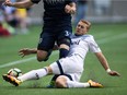 Vancouver Whitecaps' Brett Levis, right, slides to take the ball away from Sporting Kansas City's Cameron Porter during first half CONCACAF Champions League soccer action in Vancouver, B.C., on Tuesday August 23, 2016. The Vancouver Whitecaps have announced that Brett Levis underwent successful surgery on his right knee.