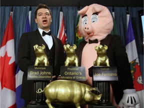 Canadian Taxpayers Federation Director Aaron Wudrick and pig mascot Porky the Waste Hater stand behind the CTF awards after they presented the 17th Annual Teddy Government Waste Award Winners during a news conference in Ottawa, Wednesday, March 4, 2015.
