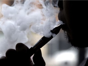 The federal government has passed legislation that makes significant changes to tobacco laws by regulating vaping products and giving Health Canada the power to order plain packaging for cigarettes. A man smokes an electronic cigarette in Chicago in this April 23, 2014 file photo.