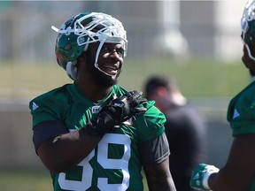 Saskatchewan Roughriders defensive end Charleston Hughes chats with a teammate during day one of Rider training camp at Griffiths Stadium in Saskatoon, Sask. on May 20, 2018.