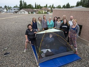 A group of staff and teachers from Lakeridge school stand for a photograph with their tents, which they will be spending the night in, on the school's roof in Saskatoon, SK on Thursday, June 7, 2018.