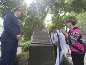 Mayor Charlie Clark, from left, Harry Lafond with the Office of the Treaty Commissioner and Sharolyn Dickson unveil a plaque to honour artist Joni Mitchell at River Landing in Saskatoon on Sunday, June 10, 2018.