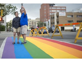 Rob Norris and his daughter, JQ, who identifies as queer, take a selfie on the rainbow crosswalk celebrating Pride outside of City Hall in Saskatoon, SK on Thursday, June 14, 2018.