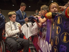 Surviving members of the Humboldt Broncos Ryan Straschnitzki, left, and  Reagan Poncelet signs autographs on the fan red carpet prior the NHL awards at the Hard Rock Hotel in Las Vegas, NV on Tuesday, June 20, 2018.