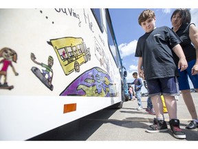 Grade 3 student Morgan Milligan, age 10, from College Park School, points out he and his classmates artwork displayed on a Saskatoon Transit bus during a media event at Civic Operations Centre in Saskatoon, SK on Monday, June 25, 2018.