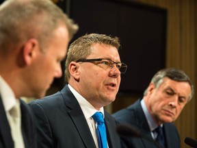 Premier Scott Moe, centre, speaks about the Saskatchewan government's position on a federally-imposed carbon tax at the provincial legislative building while flanked by Minister of Environment Dustin Duncan and Attorney General Don Morgan.
