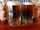 A bartender serves two mugs of beer at a tavern in Montpelier, Vt. An Alberta judge has ruled the government's mark-up policy on craft beer is unconstitutional.