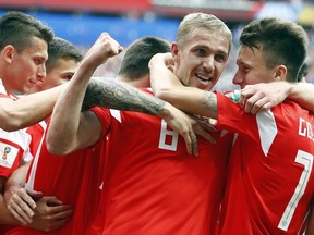 Russia's Yuri Gazinsky celebrates with teammates after scoring his side's first goal during the group A match between Russia and Saudi Arabia which opens the 2018 soccer World Cup at the Luzhniki stadium in Moscow, Russia, Thursday, June 14, 2018.