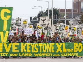 In this Aug. 6, 2017, file photo, demonstrators against the Keystone XL pipeline march in Lincoln, Neb. The developer of the pipeline is showering Nebraska public officials with campaign cash as it fights for regulatory approval in a state that is one of the last lines of resistance for the $8 billion project. Pipeline opponents say the company's contributions show it's trying to exert influence over the state's top elected officials at the expense of landowners who don't want the pipeline running through their property.