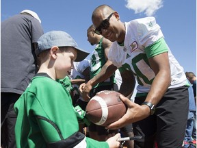 Spencer Moore signs a ball for Humboldt redundant Ben Hinz during a Saskatchewan Roughrider practice and autograph session at Glen Hall Park in Humboldt, Sask. on Sunday, June 3, 2018.