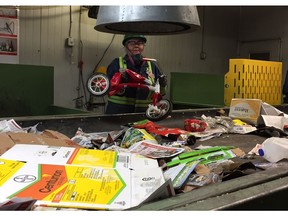 Carlene Brown, a line sorter at the Loraas Recycle facility in Saskatoon, Sask., holds a tricycle pulled off the line on Wednesday, June 27, 2018. The rate of contaminate items going into the facility has increased by more than 75 per cent in the last three years, causing growing concerns for the safety of the employees.