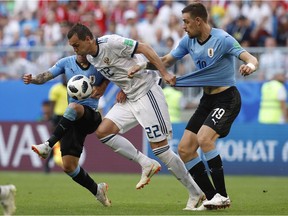 Uruguay's Lucas Torreira, from left, Russia's Artyom Dzyuba and Uruguay's Sebastian Coates challenge for the ball during the group A match between Uruguay and Russia at the 2018 soccer World Cup at the Samara Arena in Samara, Russia, Monday, June 25, 2018.