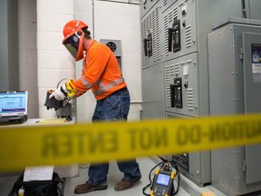 Devin Kress, metering electrician supervisor with SaskPower, demonstrates the installation of a new power meter at the Crown's testing facility on Powerhouse Drive.