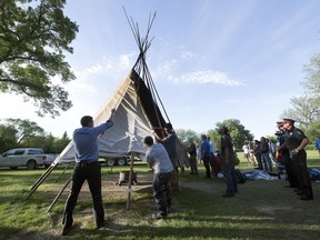 Members of the Wascana Centre Authority and the Provincial Capital Commission work on taking down the teepee at the Justice For Our Stolen Children camp outside the Saskatchewan Legislative Building in Regina.