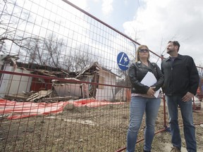 Shannon Vinnish (L) and Daniel Gerle stand for a photo outside a home on the Corner of Avenue B and 34th Street that has been left partly demolished for more than six months with asbestos warnings on the fence in Saskatoon, SK on Wednesday, April 25, 2018.