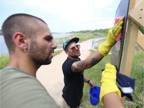 Lucas Regazzi (left) and Derek Sandbeck (right) work to clean off an art installation that was sawed down and spray painted over during the Canada Day long weekend. Photo taken July 6.